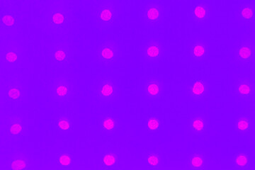 Abstract purple paper background with holes arranged in a row and glowing with neon color