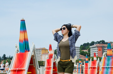 Beautiful happy woman walking, relaxing, enjoying in sunny day at beach. Summer. Drinking coffee. Adriatic Sea.