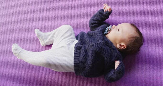 Video of caucasian newborn baby sleeping on violet blanket