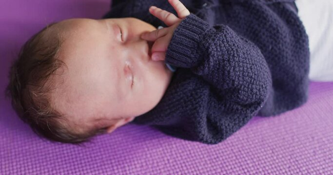Video of caucasian newborn baby sleeping on violet blanket