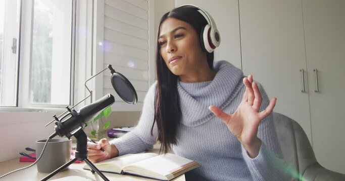 Video of biracial woman in headphones taking part in online interview on laptop at home