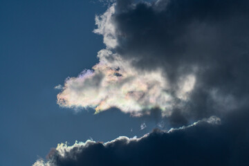 Dark gray clouds fly across the sky. Puffy fluffy grey clouds at spring day during sunset