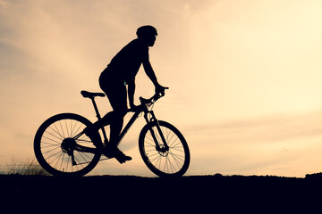 Fototapeta na wymiar Silhouettes of mountain bikes and cyclists in the evening happily. Travel and fitness concept