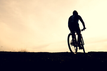 Silhouettes of mountain bikes and cyclists in the evening happily. Travel and fitness concept