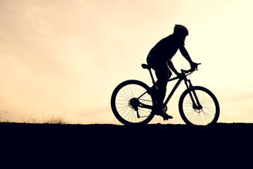Fototapeta na wymiar Silhouettes of mountain bikes and cyclists in the evening happily. Travel and fitness concept