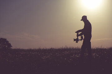 Professional Cameraman Filming On Sunrise Using Gimbal Stabilizer - obrazy, fototapety, plakaty