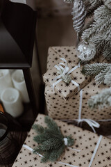 Beautiful Christmas gifts under fir tree on floor in room. Christmas tree with rustic decorations and presents under it 