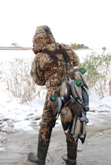 A waterfowl hunter with a string of decoys 
