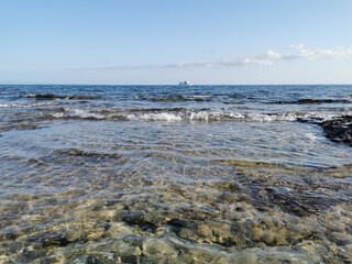 Fototapeta premium The Mediterranean Sea, in which a white pleasure yacht floats against a blue sky with clouds.