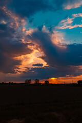 Beautiful sunset with a dramatic sky and overland high voltage lines near Tabertshausen, Bavaria, Germany