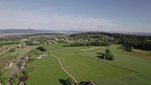 Aerial round shot view with agricultural landscape and Lake Greifensee seen from village Forch on a sunny summer day. Movie shot June 8th, 2022, Forch, Switzerland.