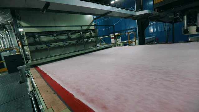 Synthetic winterizer on the conveyor line, close-up. Factory for the production of non-woven materials. Production of synthetic winterizer close-up. Syntepon manufacturing process