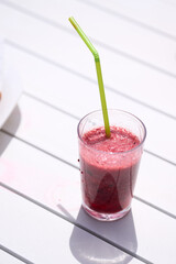 Glass with natural smoothie of red fruits, strawberry and blueberries