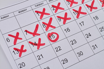 Paper calendar with red crosses and circle closeup-up. Business appointment concept.