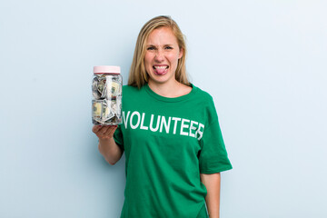 young adult blonde woman feeling disgusted and irritated and tongue out. volunteer and donation...