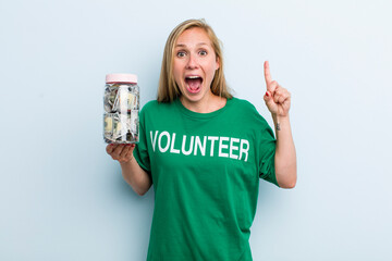 young adult blonde woman feeling like a happy and excited genius after realizing an idea. volunteer...