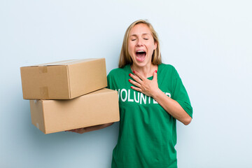 young adult blonde woman laughing out loud at some hilarious joke. volunteer and donation concept