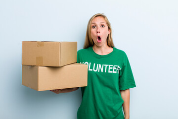 young adult blonde woman looking very shocked or surprised. volunteer and donation concept