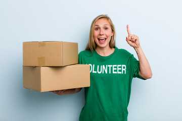 young adult blonde woman feeling like a happy and excited genius after realizing an idea. volunteer...