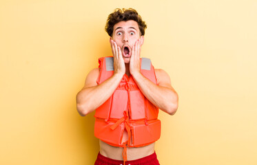 young handsome guy feeling shocked and scared. life jacket and boat concept