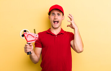 young handsome guy screaming with hands up in the air. packer emnployee concept