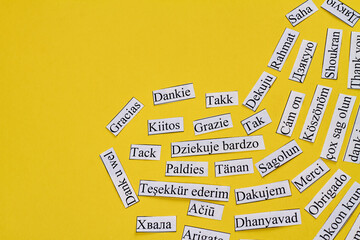 Thank you in many different languages arranged in a heart. Isolated on yellow background.