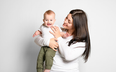 Cheerful baby boy toddler with his mother on white studio background