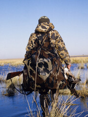 A waterfowl hunter returning with his bag