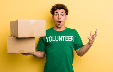 young handsome guy feeling extremely shocked and surprised. donation and volunteer concept