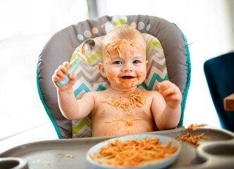 Little baby eating her dinner and making a mess