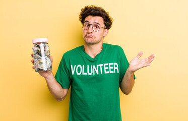 young handsome guy feeling puzzled and confused and doubting. donation and volunteer concept