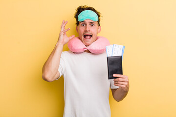 young handsome guy screaming with hands up in the air. flight passenger concept