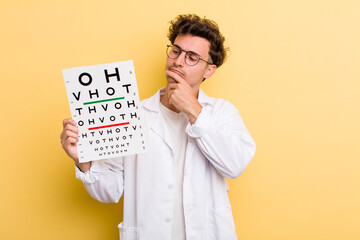 young handsome guy thinking, feeling doubtful and confused. optical vision test concept
