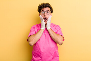 young handsome guy feeling shocked and scared. nurse concept
