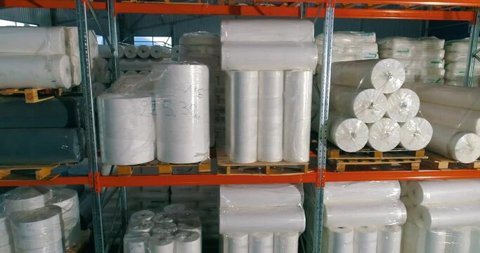 Warehouse at the nonwovens factory. Flight to the warehouse of non-woven fabrics. Large modern warehouse with synthetic winterizer rolls