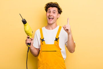 young handsome guy feeling like a happy and excited genius after realizing an idea. handyman with a...