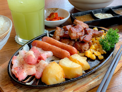 Various menus, sushi, sashimi, nigiri, pan fried pork and miso soup. Sashimi, chutoro sashimi, Japanese food chopsticks and wasabi on the black table, Japanese food style. blurs focus.