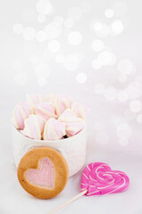 Cookies and sweets on a white background. Pink lollipop heart and love. Sweets are harmful to teeth and dental treatment