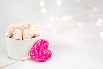 Candies and sweets on a white background. Lollipop heart and love. Sweets are harmful to teeth and dental treatment