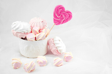 Candies and sweets on a white background. Lollipop heart and love. Sweets are harmful to teeth and dental treatment
