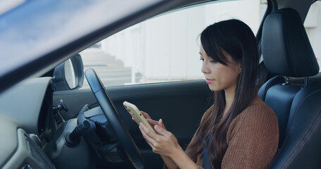 Woman check location on cellphone before drive her car