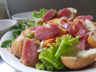 Fermented pork roll eat with bread, salad, onion, carot.