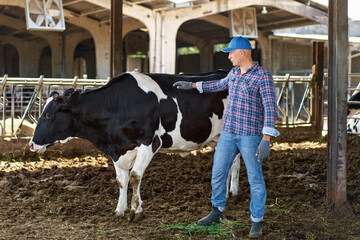 agricultural worker posing in a cowshed