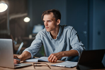 smiling businessman working on a new project at night .