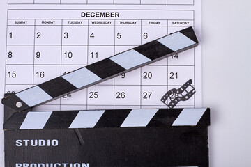 Calendar december with mark on 28 day and cinema clapperboard. Cinema day concept.
