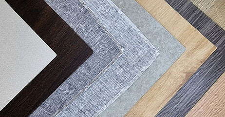 stack of various construction material samples including fabric laminated, grey drapery, wooden laminated and veneer (focused at grey fabric texture). sampler material texture for interior design.