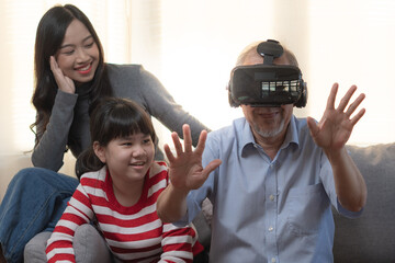 Elderly father with family playing games in metaverse through VR glasses