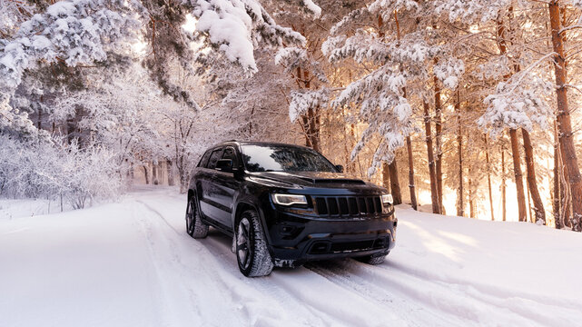 Moscow, Russia - June 09, 2022 Jeep grand cherokee wk2 Trackhawk. The car is in the forest in winter. snowy forest light breaks through the trees