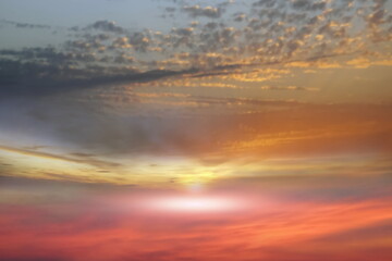 Fototapeta na wymiar orange yellow blue cloudy sky and pink sun beam on sunset evening hature landscape