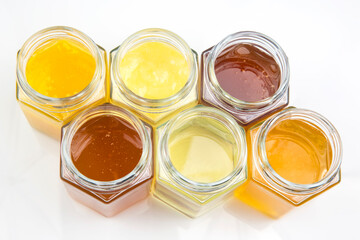 Hexagonal jars with different types and colors of fresh flower honey. vitamin food for health and life